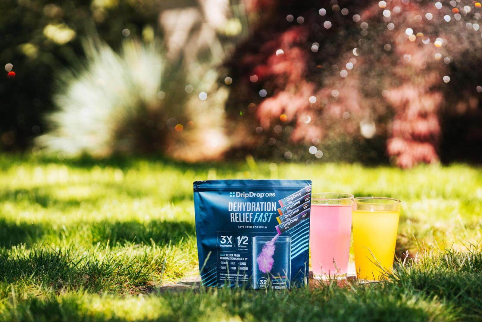 DripDrop ORS pack and 2 glasses of DripDrop on the ground