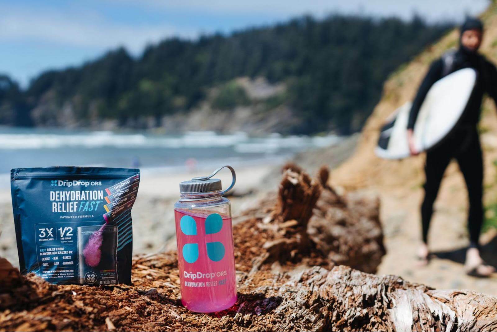 DripDrop pack and tumbler on a rock near the sea