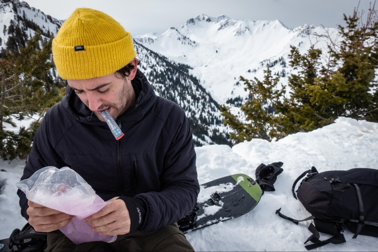 Snowboarder mixing DripDrop ORS with water while outdoors