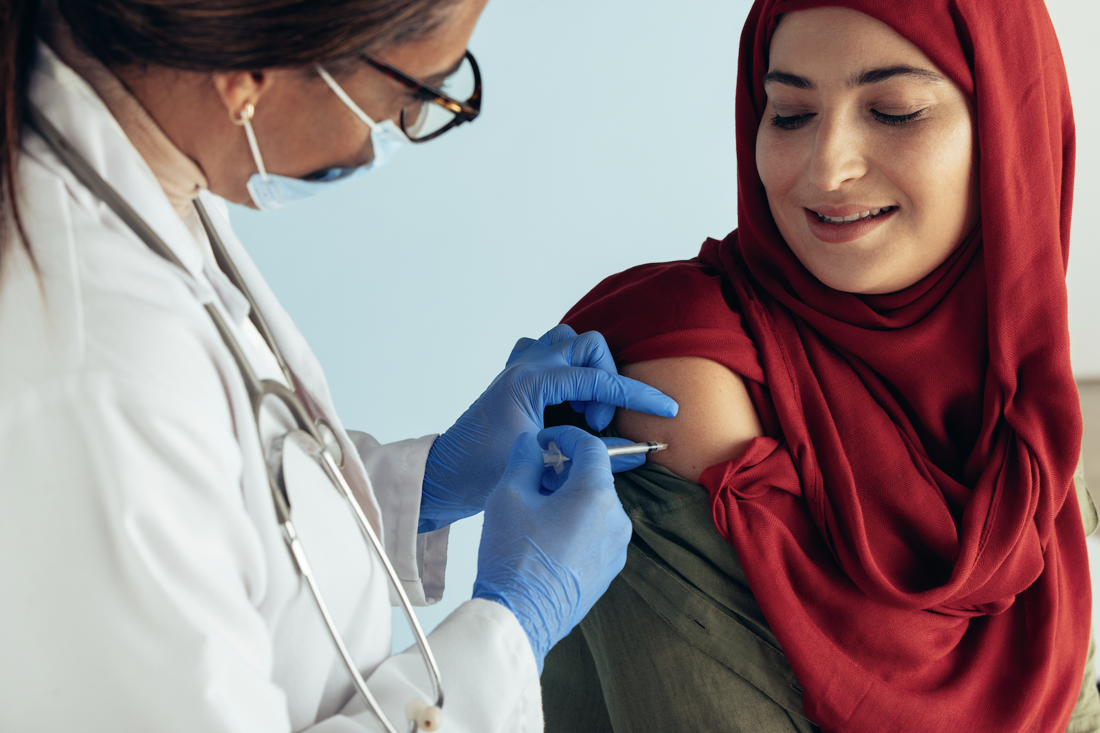 preparation for COVID vaccine: doctor vaccinating a woman