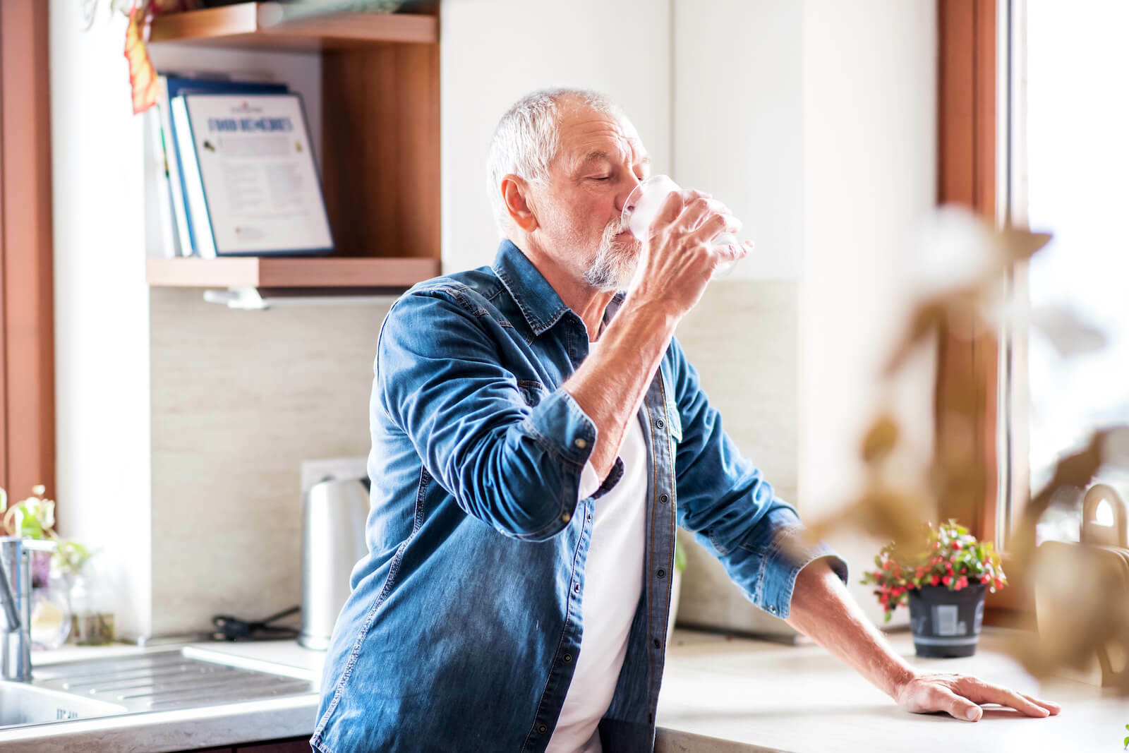 How to rehydrate fast: elderly man drinking a glass of water