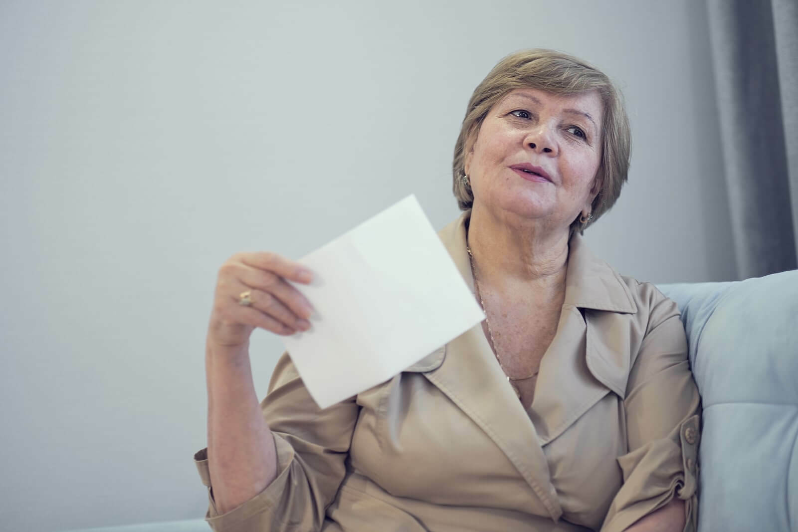 Elderly woman fanning herself with a piece of paper