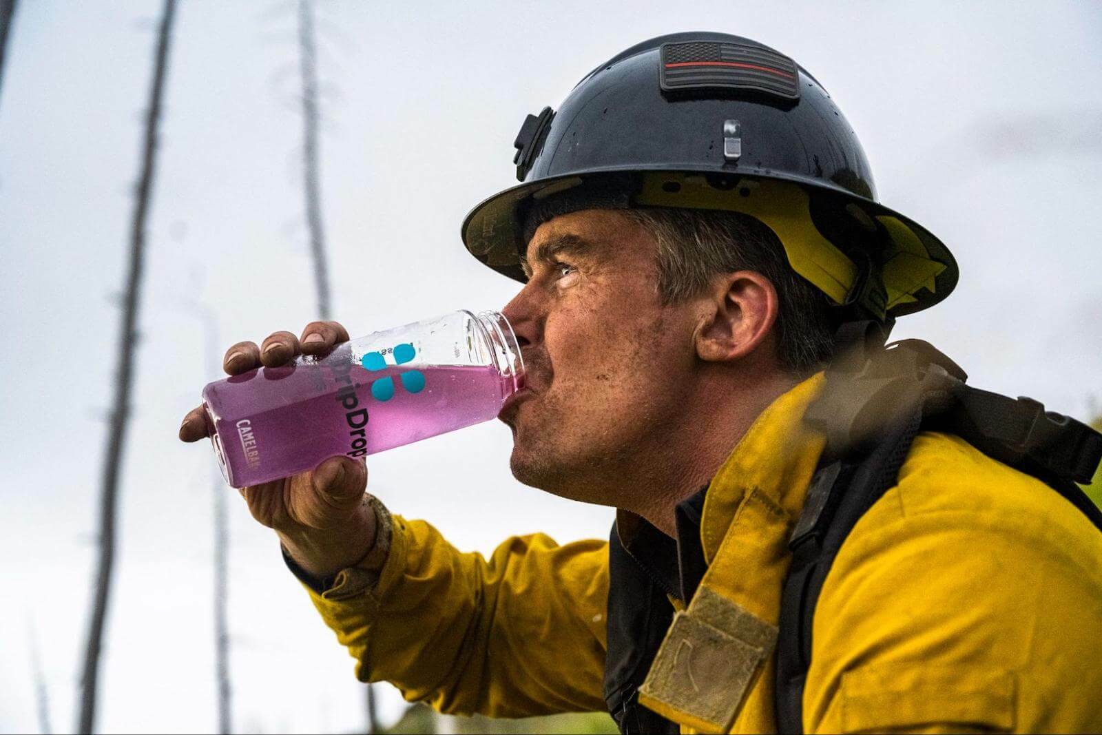 Fireman drinking DripDrop from a tumbler