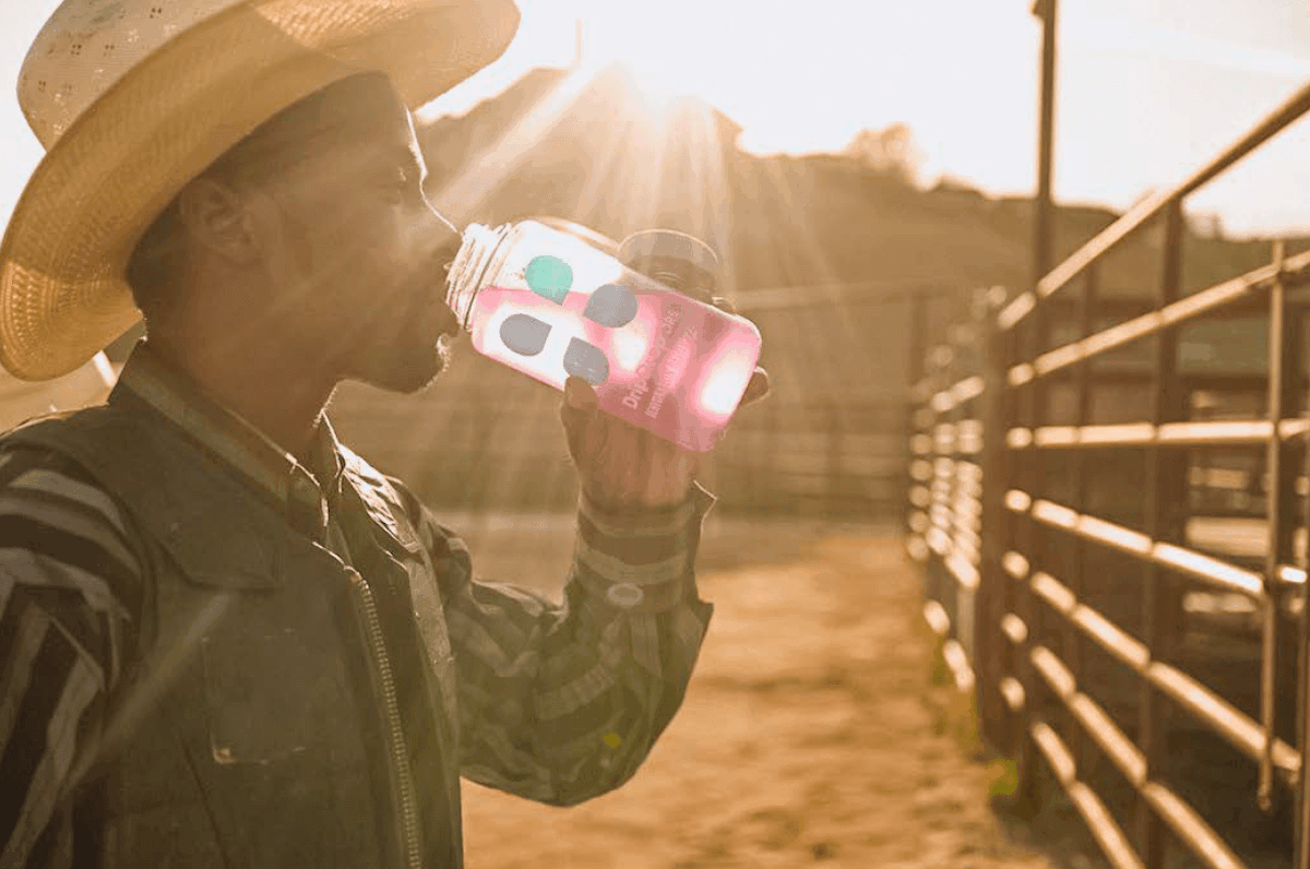 Is water an electrolyte: man drinking DripDrop ORS under the heat of the sun