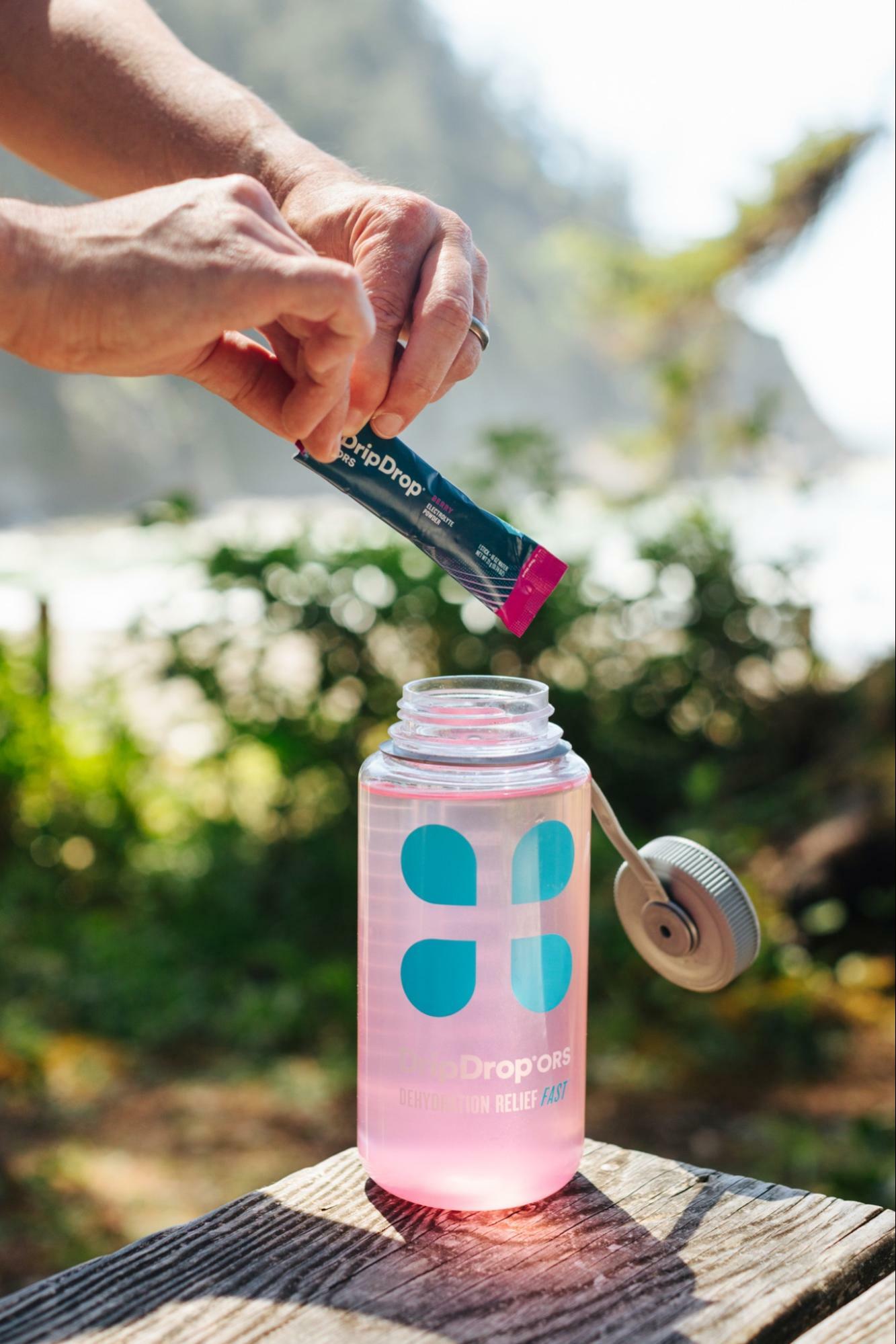 man pouring DripDrop ORS in his DripDrop ORS bottle