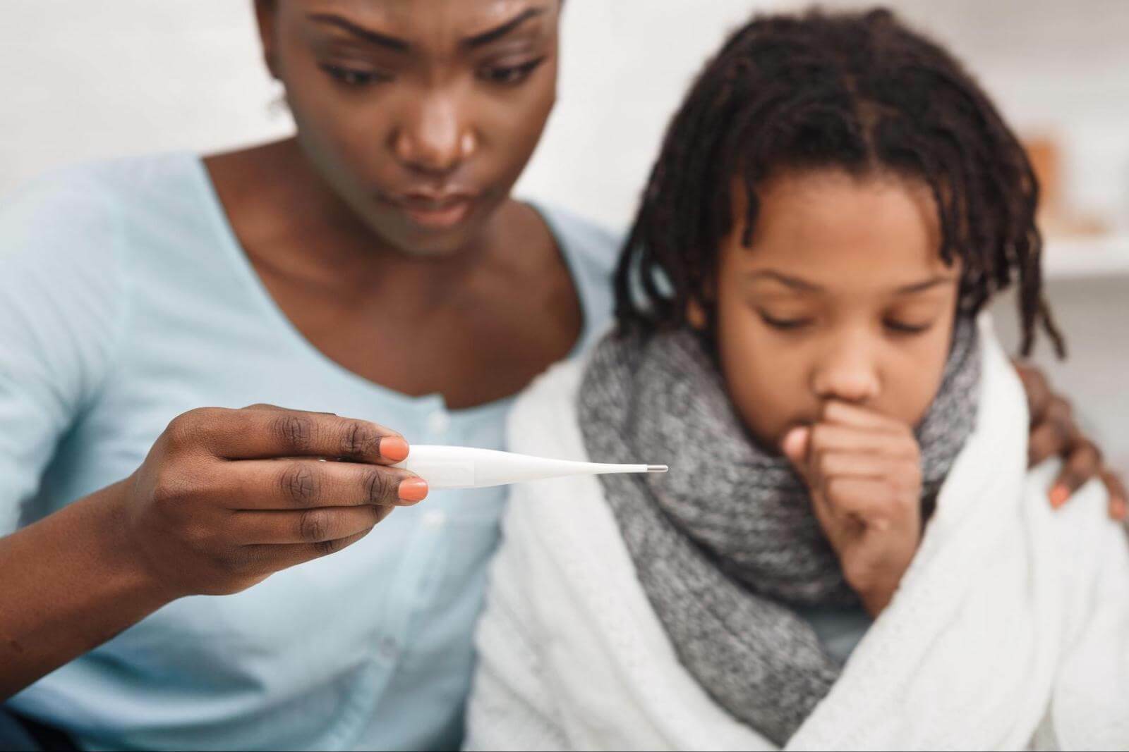 Cold sweats: mom checking the temperature of her sick child