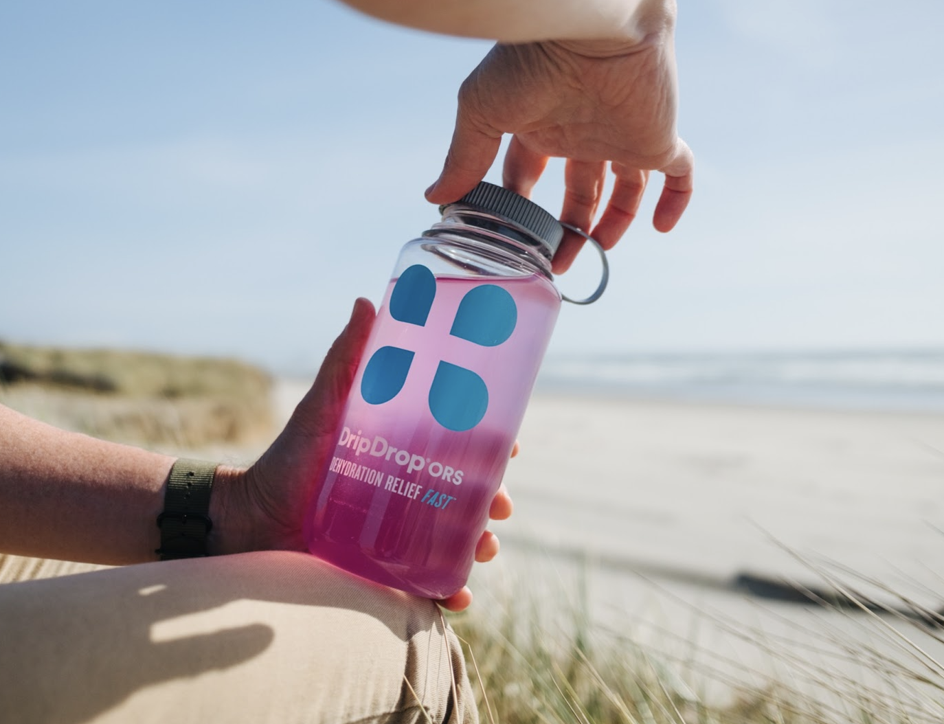 cloudy urine dehydration: Person holding a tumbler with DripDrop ORS