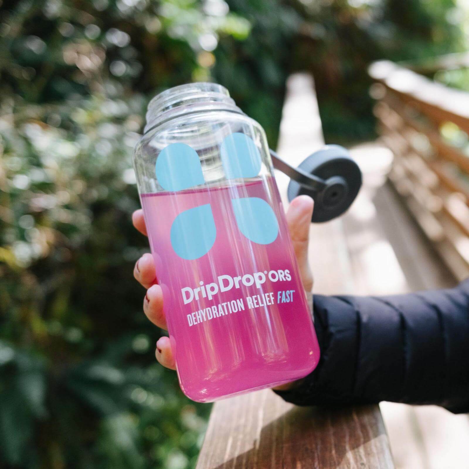 Person holding an open tumbler of DripDrop ORS