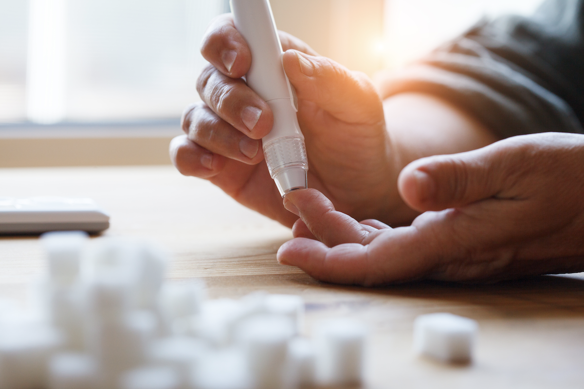 does sugar dehydrate you: Person testing blood sugar using a lancet