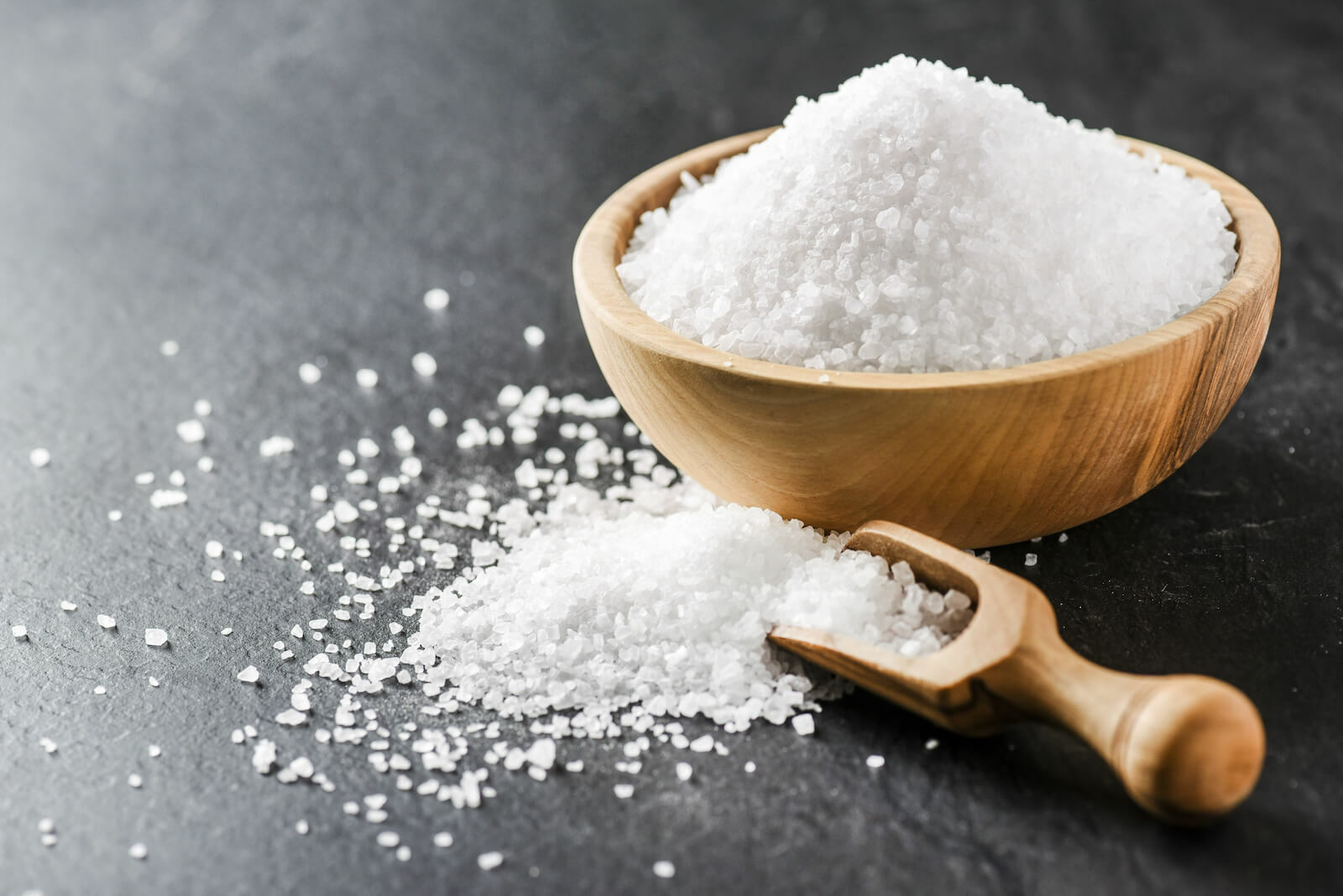 Electrolytes benefits: sea salt in a wooden spoon and bowl