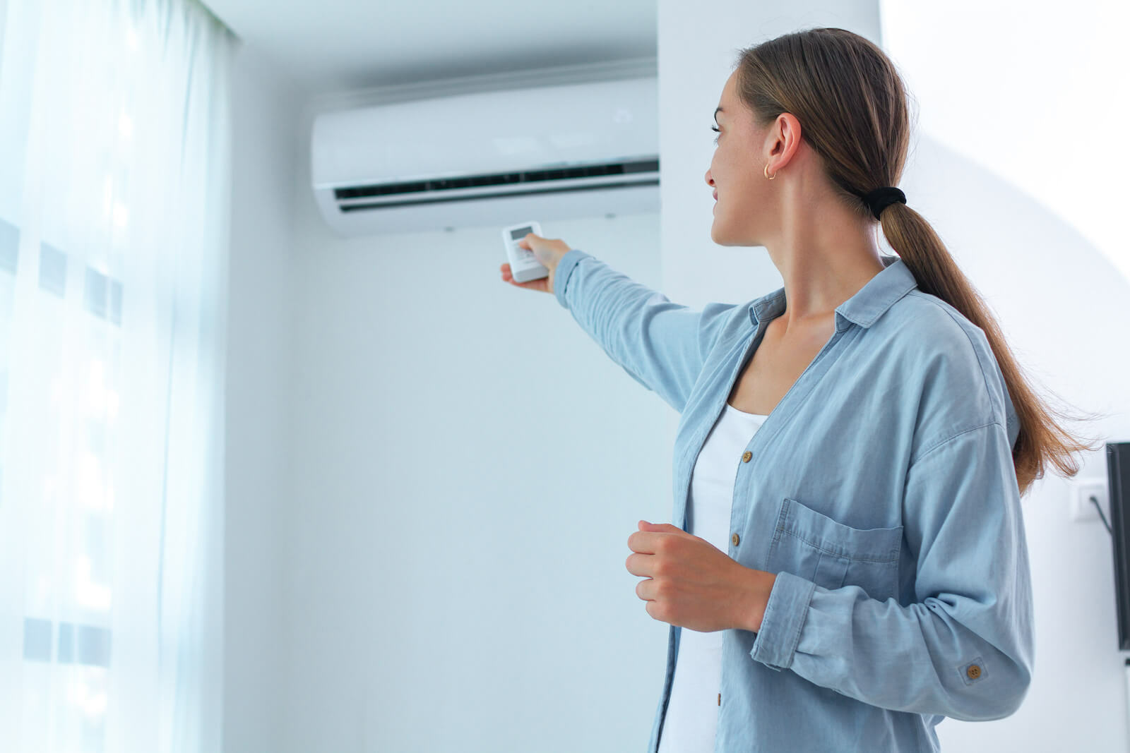 How to cool down: woman adjusting the aircon temperature